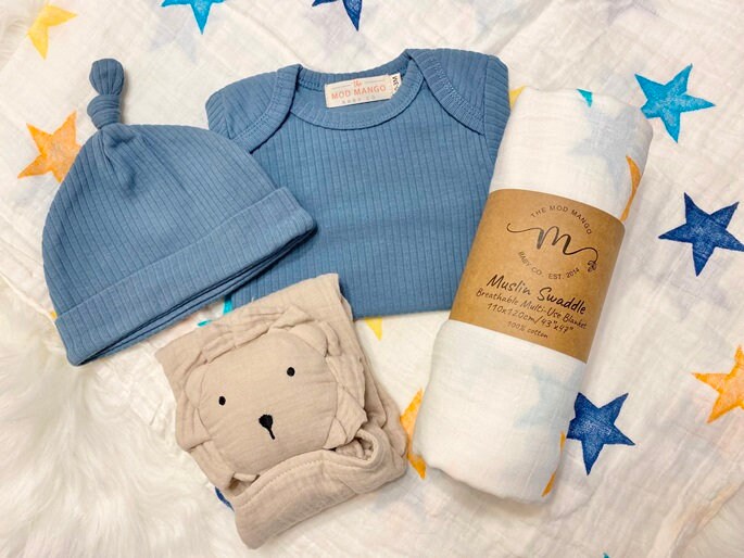 colorful stars baby boy gift, newborn boy gift set, gift baby boy, swaddle blanket, blue ribbed knit long sleeve bodysuit with knot hat, muslin swaddle organic cotton gift set baby boy, lion lovey comforter blanket, yellow turquoise baby gift