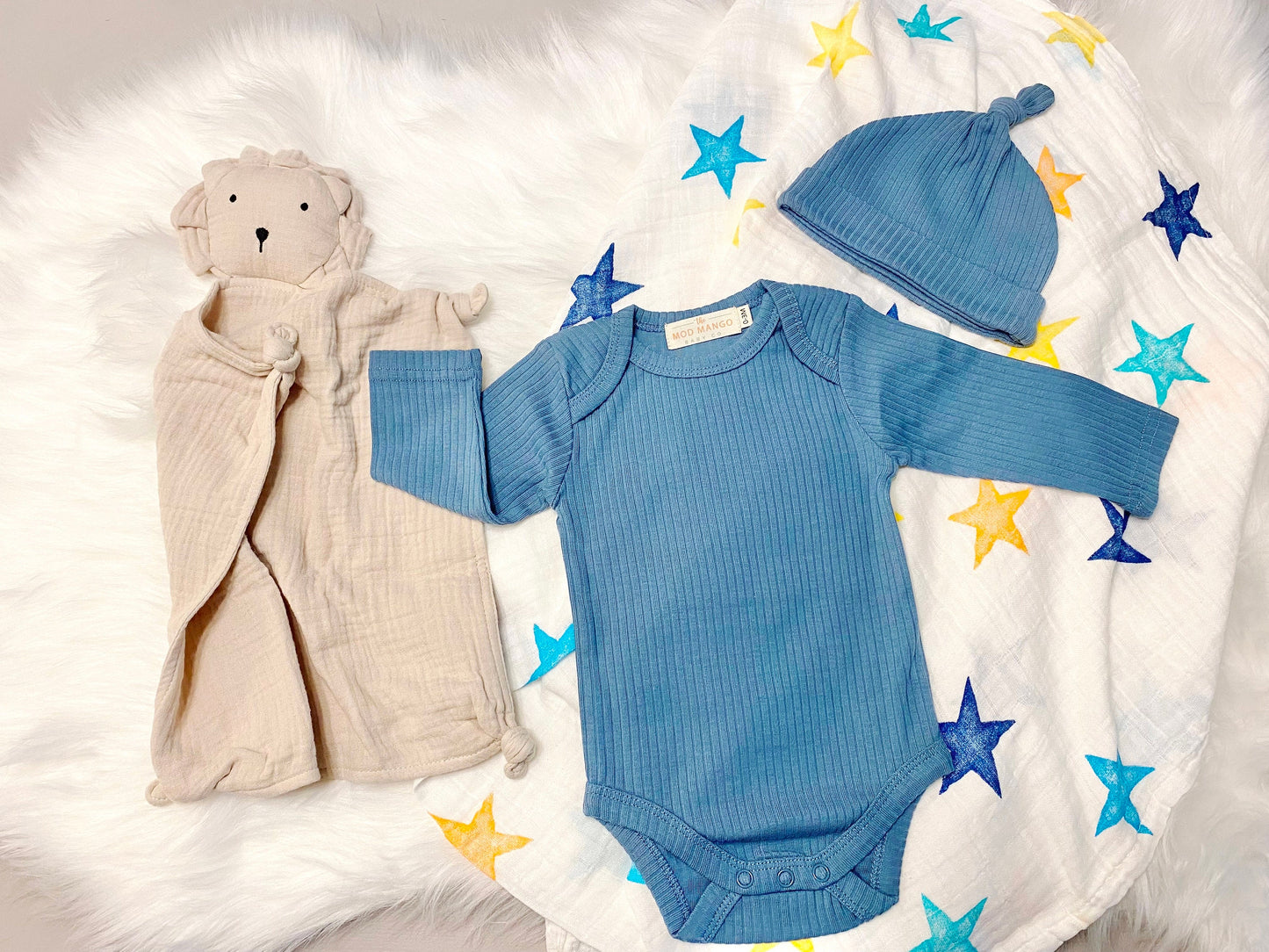 colorful stars baby boy gift, newborn boy gift set, gift baby boy, swaddle blanket, blue ribbed knit long sleeve bodysuit with knot hat, muslin swaddle organic cotton gift set baby boy, lion lovey comforter blanket, yellow turquoise baby gift