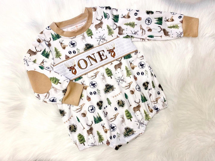 the big one deer hunting shirt first birthday boy romper fall green brown tan beige outfit, ONE smocked bubble romper first birthday deer buck trees antlers, party deer embroidered smocked 1st birthday outfit romper baby boys camo camouflage, the mod mango baby boutique co