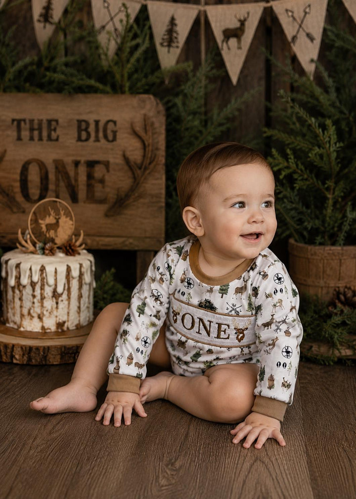 the big one deer hunting shirt first birthday boy romper fall green brown tan beige outfit, ONE smocked bubble romper first birthday deer buck trees antlers, party deer embroidered smocked 1st birthday outfit romper baby boys camo camouflage, the mod mango baby boutique co
