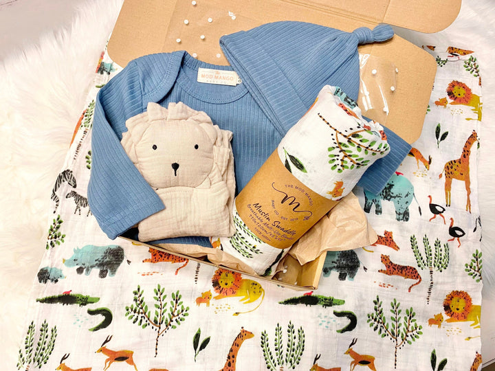 Unique baby boy gift, newborn boy gift set, gift baby boy, jungle safari swaddle blanket, blue ribbed knit long sleeve bodysuit with knot hat, muslin swaddle organic cotton gift set baby boy, lion lovey comforter blanket, baby shower gift set box, the mod mango baby boutique co