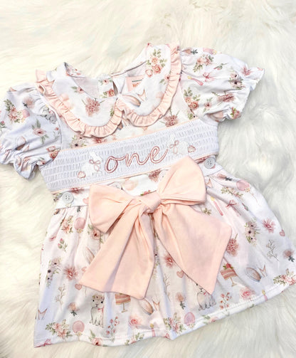 some bunny is one  pink bow first birthday girl romper pink and white outfit, girls one pink white smocked romper dress first birthday spring bunny rabbit easter bow ruffle embroidered smocked short sleeve 1st birthday outfit romper baby girls, the mod mango baby boutique co