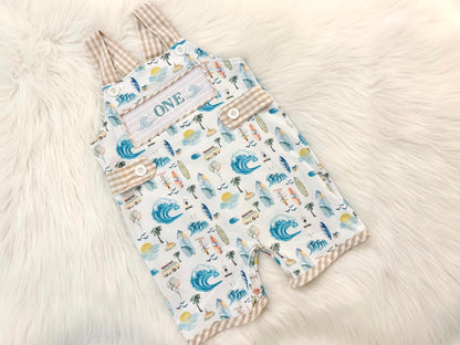 the big one first birthday boy romper my first wave summer beach surfer aqua blue tan white gingham yellow smash cake outfit overalls, ONE smocked romper first birthday beach party surfing, ocean embroidered smocked spring summer 1st birthday boy outfit romper baby boys