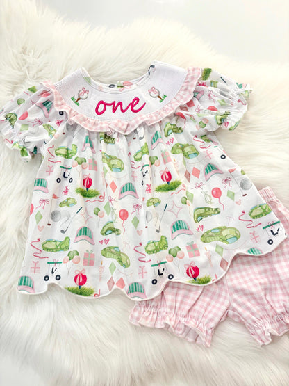 hole in one golf outfit shirt and bubble shorts first birthday girl romper spring baby pink and white gingham argyle green hot pink scalloped shirt shorts outfit, ONE smocked romper first birthday par tee, golfing golf balls embroidered smocked 1st birthday outfit romper baby girls golf first birthday outfit, the mod mango baby boutique co