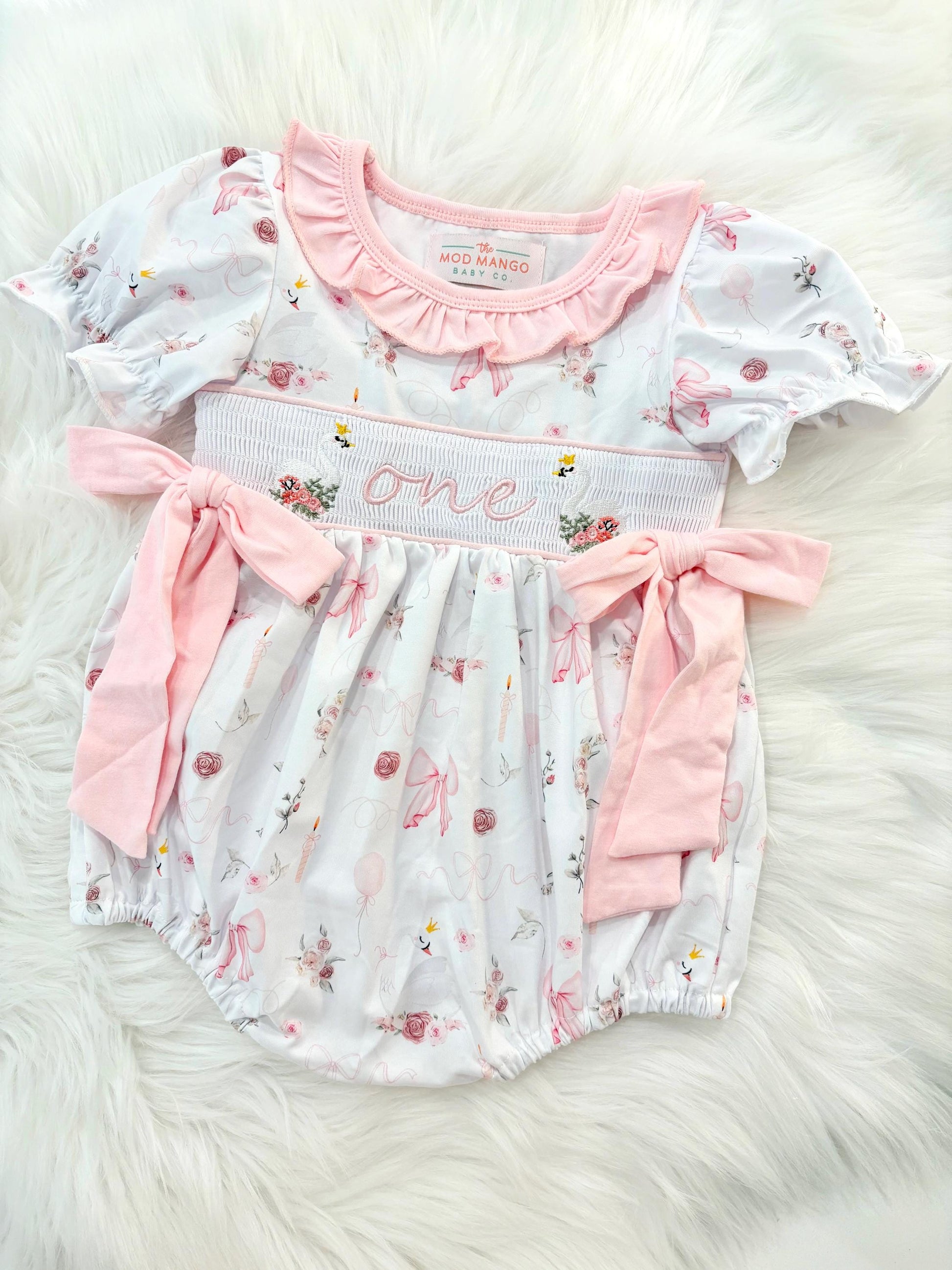 swan princess first birthday outfit bubble romper pink and white floral flowers and bows first birthday girl romper pink and white outfit, girls swans sweet white smocked bubble romper first birthday spring summer bows ruffle embroidered smocked swan 1st birthday outfit romper baby girl cake smash outfit, the mod mango baby boutique co