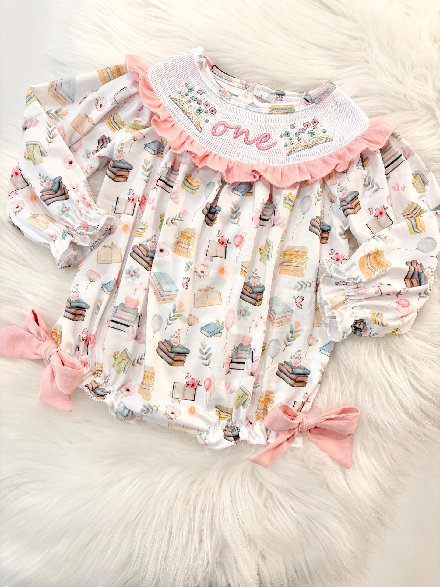 pink books flowers bows first birthday girl romper blush pink blue pastel floral and white outfit, pink and white smocked bubble romper first birthday chapter one books ruffle bows embroidered smocked long sleeve 1st birthday outfit romper baby girls, the mod mango, the mod mango baby co baby boutique