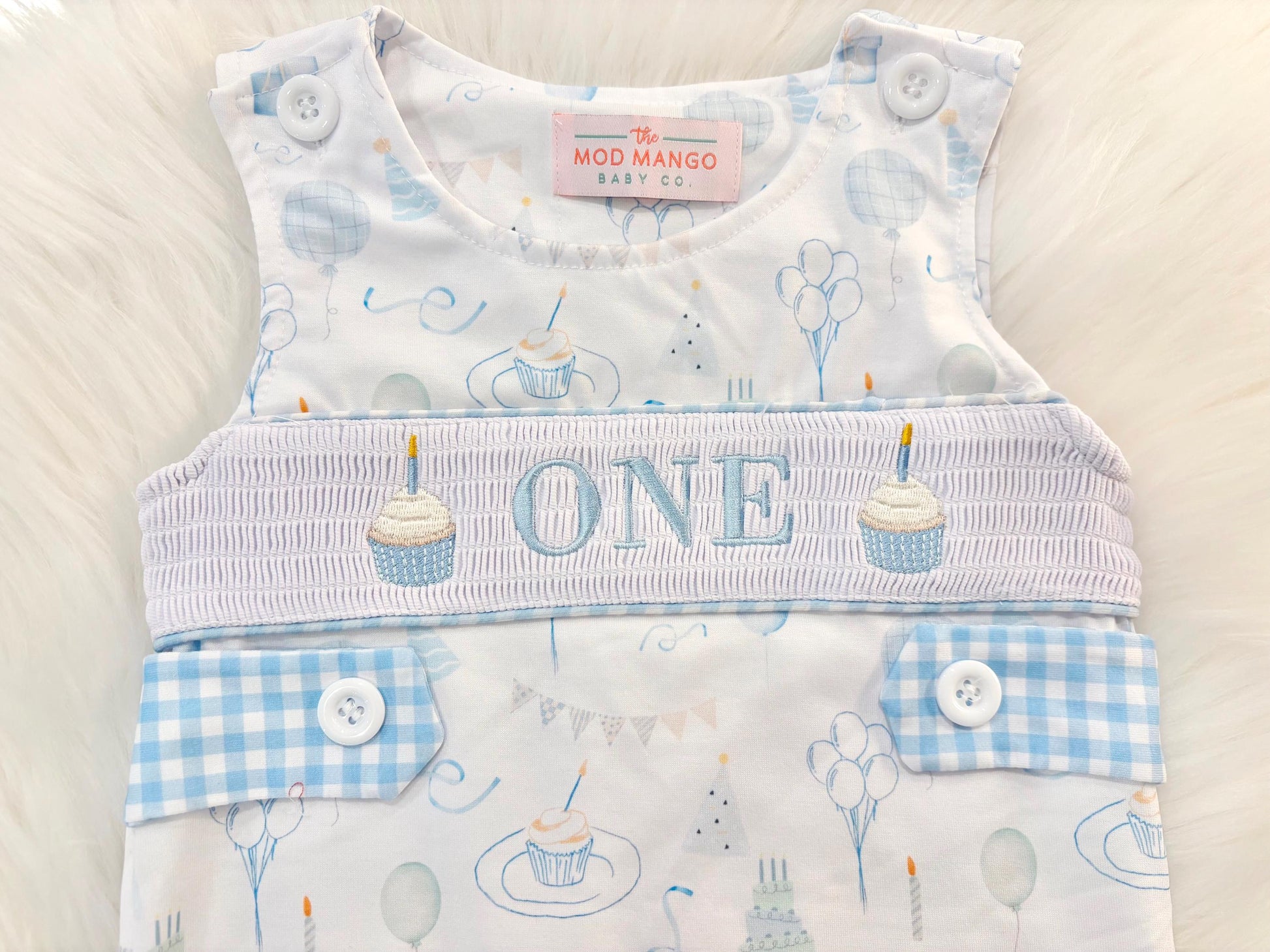 blue and white gingham checkered first birthday cupcakes romper pants outfit, one is fun first birthday outfit, it&#39;s fun to be one first birthday boy romper blue green longtalls blue white gingham smash cake outfit overalls, ONE smocked romper first birthday party hats, balloons embroidered smocked spring summer fall 1st birthday boy outfit romper baby boys 1st birthday cake smash outfit, the mod mango baby boutique co, boys first birthday outfit theme