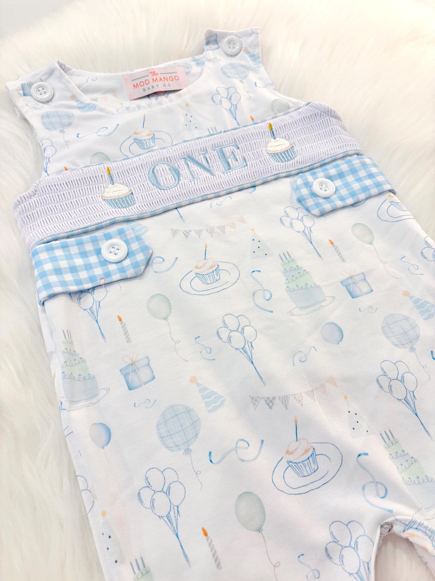 blue and white gingham checkered first birthday cupcakes romper pants outfit, one is fun first birthday outfit, it&#39;s fun to be one first birthday boy romper blue green longtalls blue white gingham smash cake outfit overalls, ONE smocked romper first birthday party hats, balloons embroidered smocked spring summer fall 1st birthday boy outfit romper baby boys 1st birthday cake smash outfit, the mod mango baby boutique co, boys first birthday outfit theme