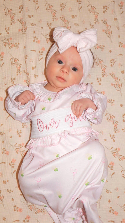 newborn girls pink and white baby gown with flowers and bows coquette for baby girl, our girl monogram baby shower gift for girl, light pink gingham baby gift, newborn coming home outfit, baby shower gift set, pregnancy announcement, custom newborn baby gown, boutique smocked baby gift set, the mod mango baby boutique co