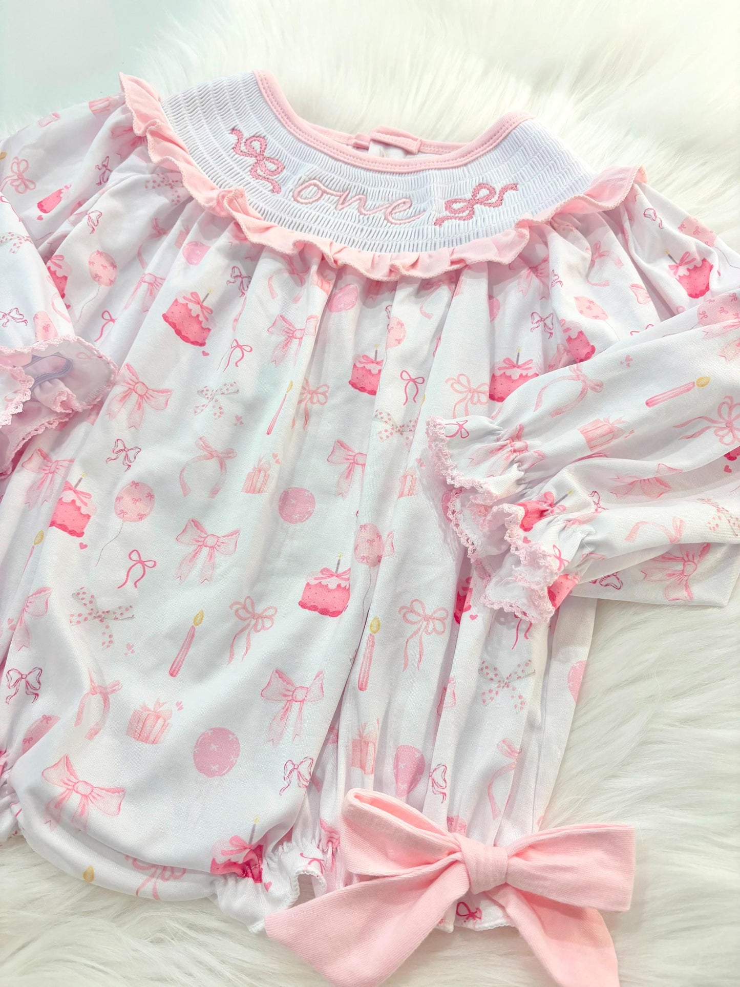 pink bow first birthday girl romper pink and white outfit, pink white smocked bubble romper first birthday winter bows ruffle bows  embroidered smocked long sleeve 1st birthday outfit romper baby girls the mod mango baby boutique