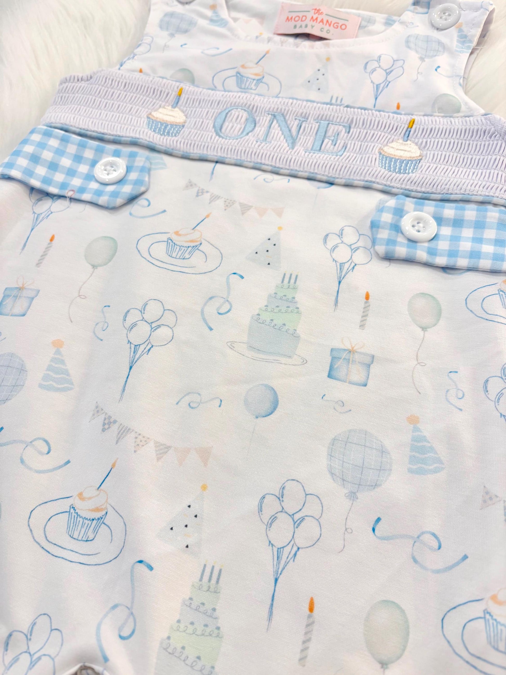 blue and white gingham checkered first birthday cupcakes romper pants outfit, one is fun first birthday outfit, it&#39;s fun to be one first birthday boy romper blue green longtalls blue white gingham smash cake outfit overalls, ONE smocked romper first birthday party hats, balloons embroidered smocked spring summer fall 1st birthday boy outfit romper baby boys 1st birthday cake smash outfit, the mod mango baby boutique co, boys first birthday outfit theme
