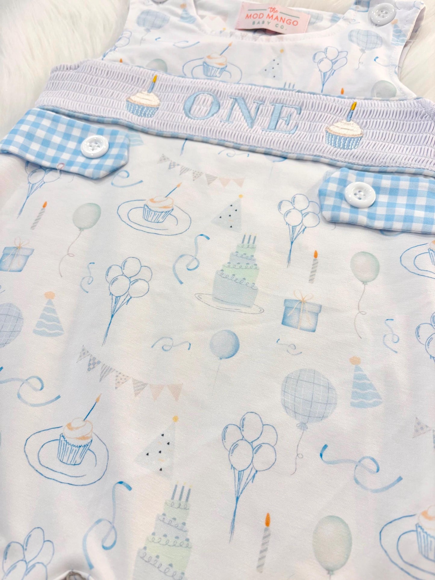 blue and white gingham checkered first birthday cupcakes romper pants outfit, one is fun first birthday outfit, it's fun to be one first birthday boy romper blue green longtalls blue white gingham smash cake outfit overalls, ONE smocked romper first birthday party hats, balloons embroidered smocked spring summer fall 1st birthday boy outfit romper baby boys 1st birthday cake smash outfit, the mod mango baby boutique co, boys first birthday outfit theme