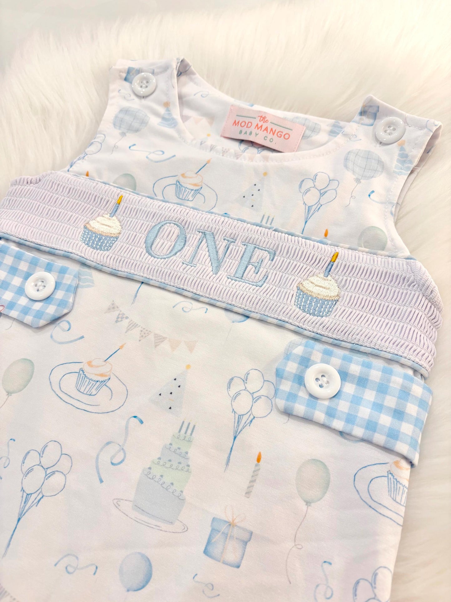 blue and white gingham checkered first birthday cupcakes romper pants outfit, one is fun first birthday outfit, it&#39;s fun to be one first birthday boy romper blue green longtalls blue white gingham smash cake outfit overalls, ONE smocked romper first birthday party hats, balloons embroidered smocked spring summer fall 1st birthday boy outfit romper baby boys 1st birthday cake smash outfit, the mod mango baby boutique co, boys first birthday outfit theme