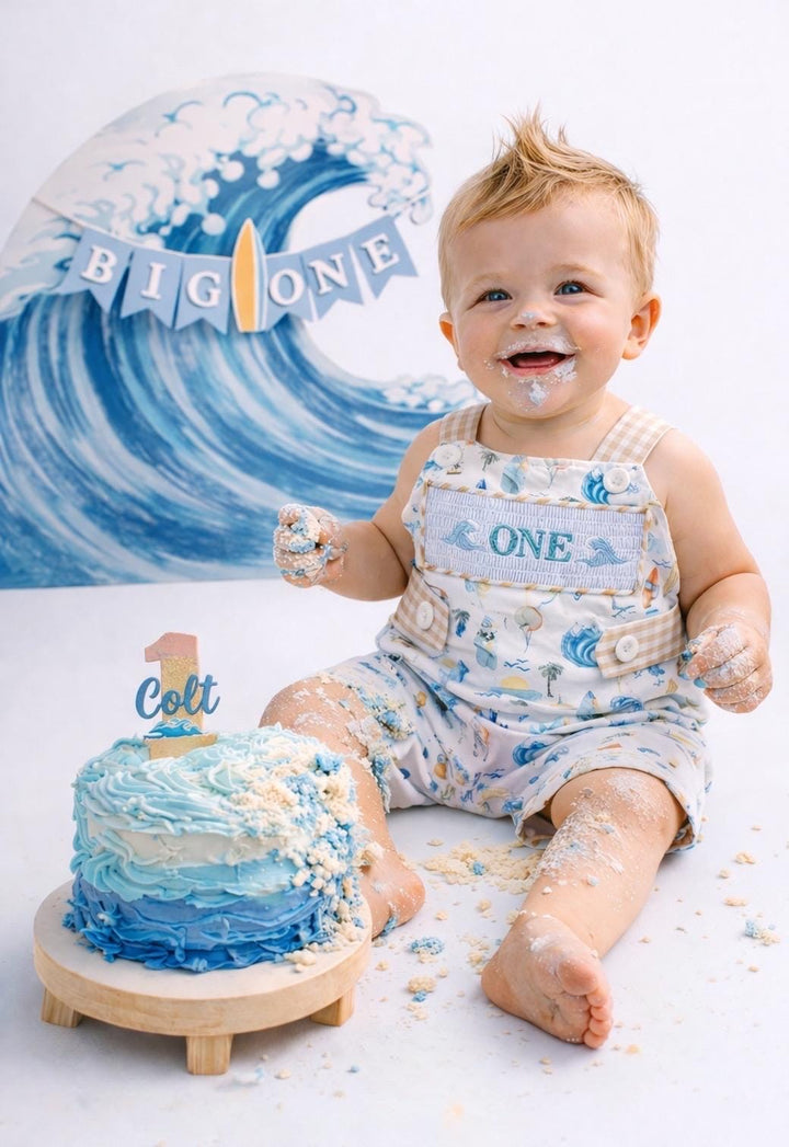 the big one first birthday boy romper my first wave summer beach surfer aqua blue tan white gingham yellow smash cake outfit overalls, ONE smocked romper first birthday beach party surfing, ocean embroidered smocked spring summer 1st birthday boy outfit romper baby boys cake smash outfit, the mod mango baby boutique co