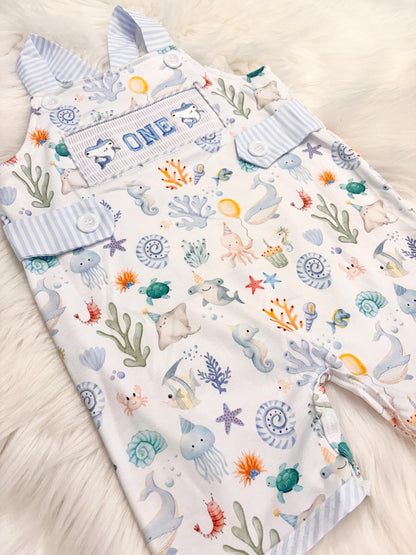 oneder the sea cake smash outfit first birthday boy romper under the sea ocean summer baby blue green white orange blue smash cake outfit overalls, ONE smocked romper first birthday sea ocean creatures party fish, beach ocean shark whale seashells octopus outdoors embroidered smocked spring summer 1st birthday boy outfit romper baby boys cake smash outfit, the mod mango baby boutique co
