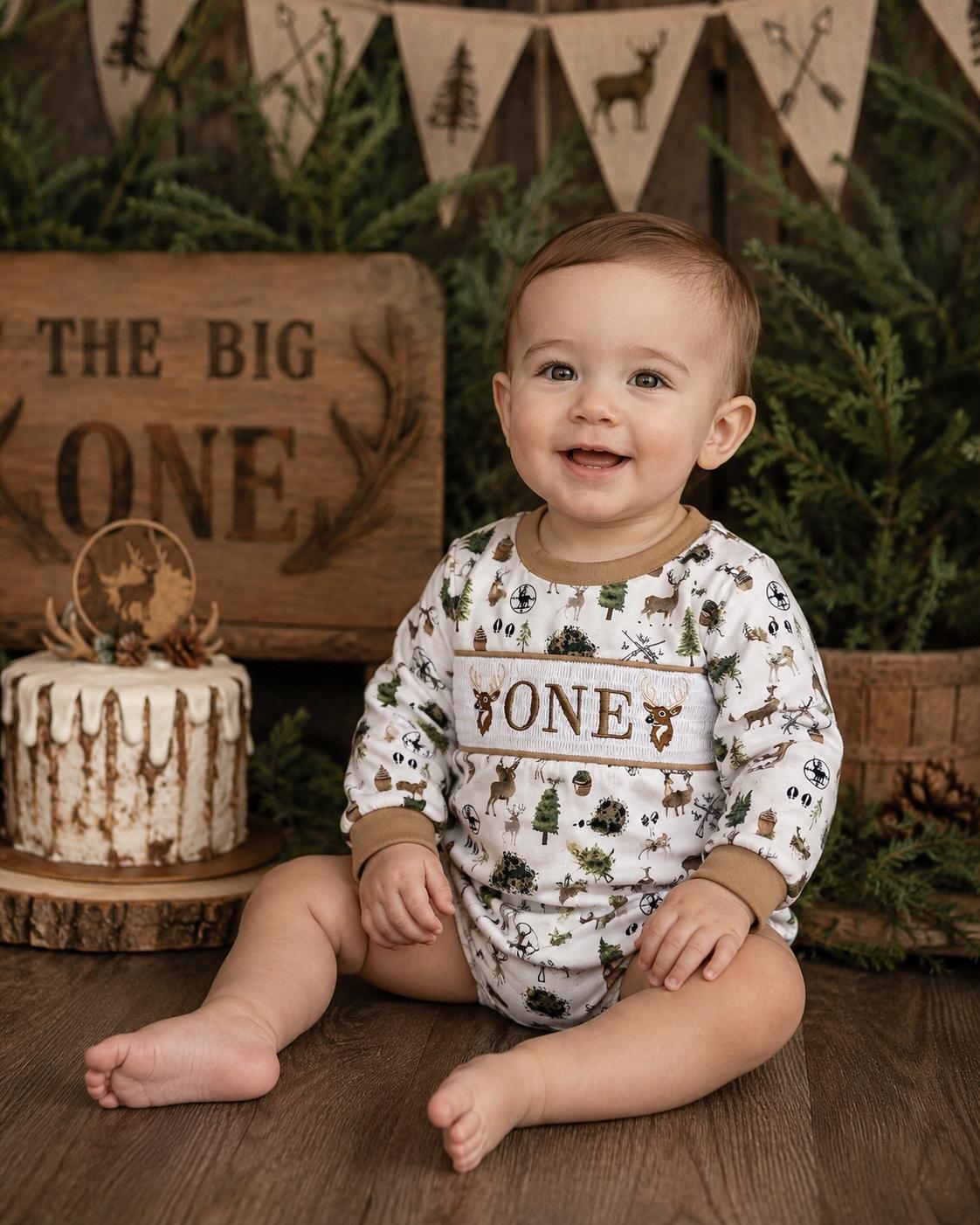 the big one deer hunting shirt first birthday boy romper fall green brown tan beige outfit, ONE smocked bubble romper first birthday deer buck trees antlers, party deer embroidered smocked 1st birthday outfit romper baby boys camo camouflage, the mod mango baby boutique co